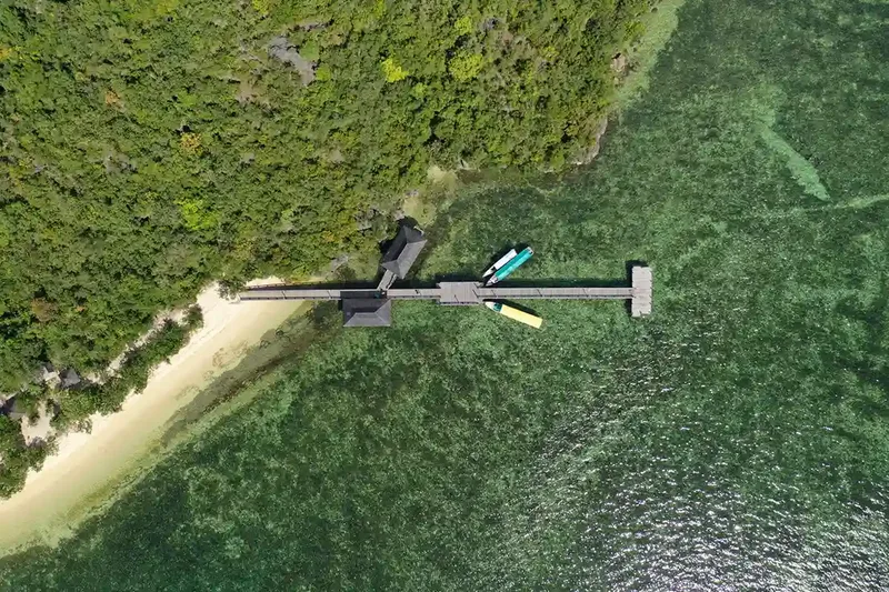 Aerial view of a jetty and forested coastline near Labuan Bajo, Flores